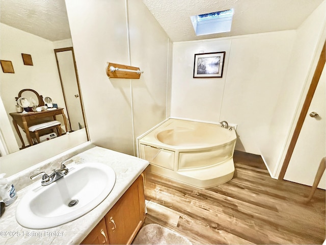 450 Stanley Allen Dr, Vine Grove, KY 40175 - full bath with a textured ceiling, a skylight, vanity, wood finished floors, and a bath
