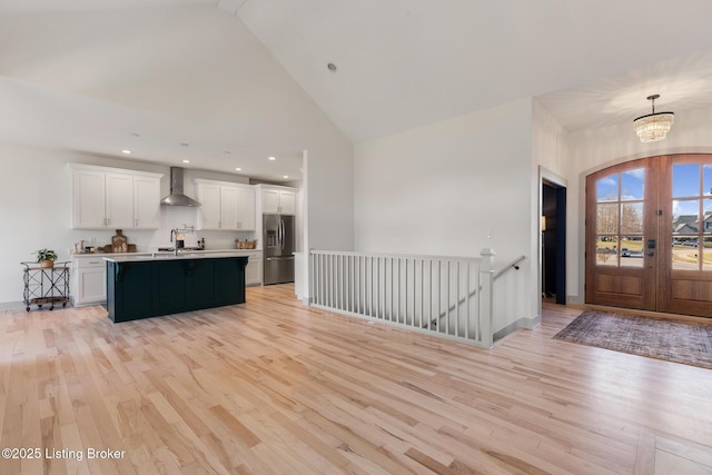 interior space with recessed lighting, high vaulted ceiling, a chandelier, and light wood finished floors