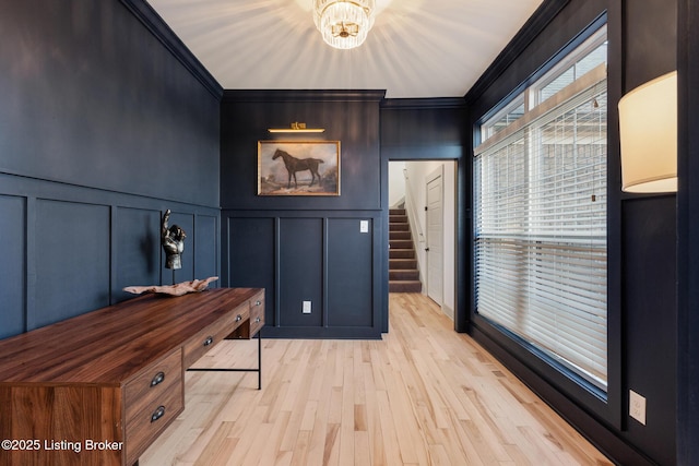 home office with a decorative wall, light wood-style flooring, an inviting chandelier, and ornamental molding