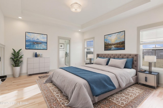 bedroom featuring a tray ceiling, recessed lighting, and light wood-style floors