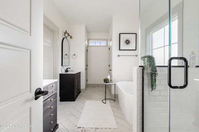 full bathroom with a freestanding bath, a stall shower, and vanity