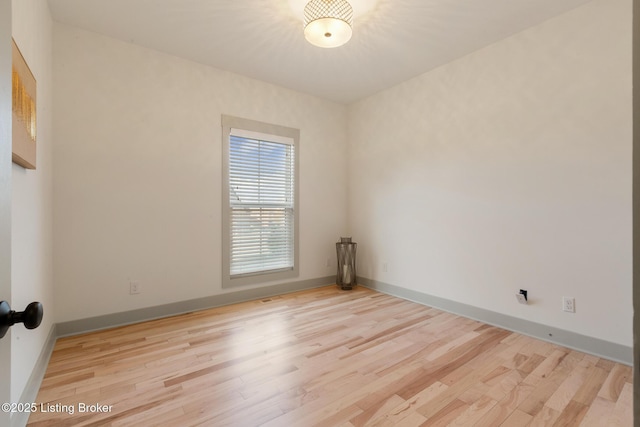 unfurnished room featuring light wood-type flooring and baseboards