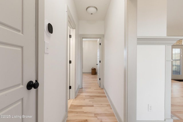 hallway featuring light wood-style floors and baseboards