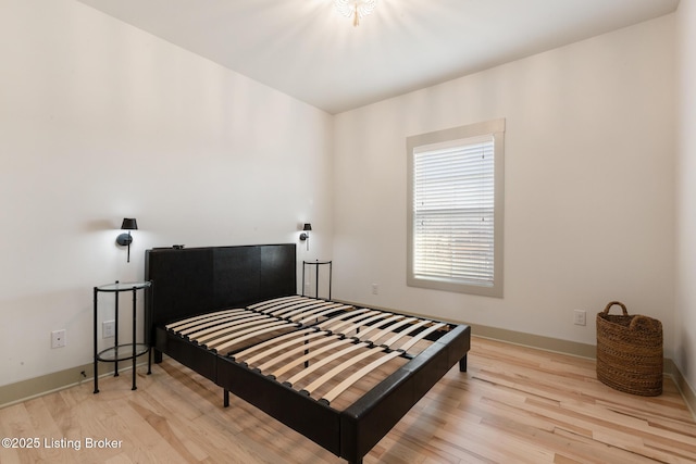 bedroom featuring baseboards and wood finished floors