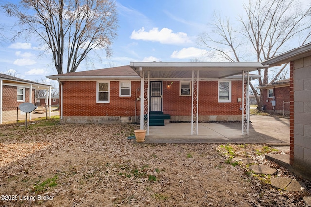 rear view of house with fence, brick siding, and entry steps