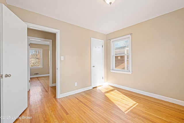 unfurnished bedroom with visible vents, baseboards, and light wood-style floors