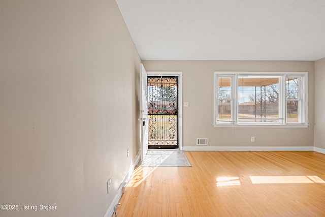 foyer with visible vents, baseboards, and wood finished floors