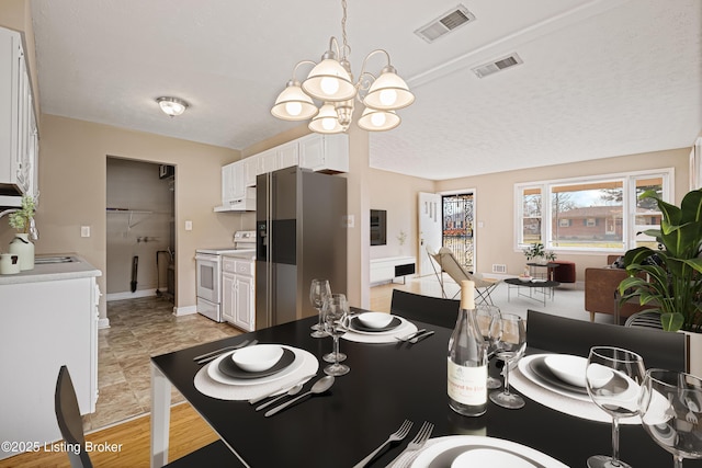 dining space featuring lofted ceiling, a notable chandelier, baseboards, and visible vents