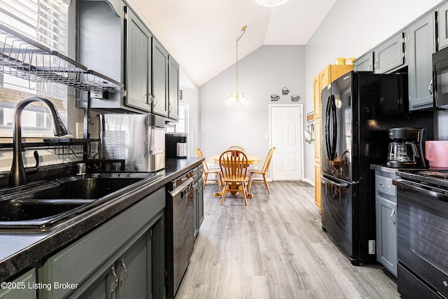 kitchen with light wood-style flooring, a sink, black appliances, dark countertops, and a chandelier