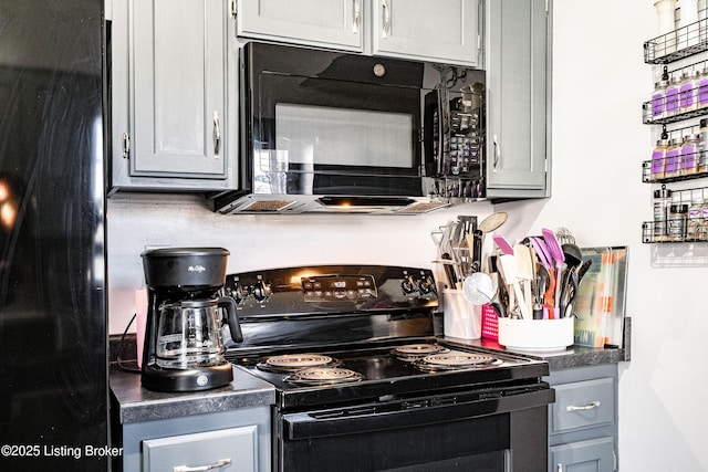 kitchen featuring dark countertops, gray cabinetry, and black appliances