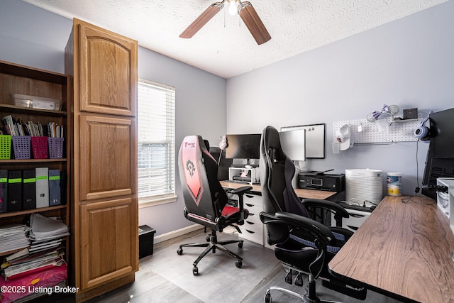 office with ceiling fan, baseboards, a textured ceiling, and wood finished floors