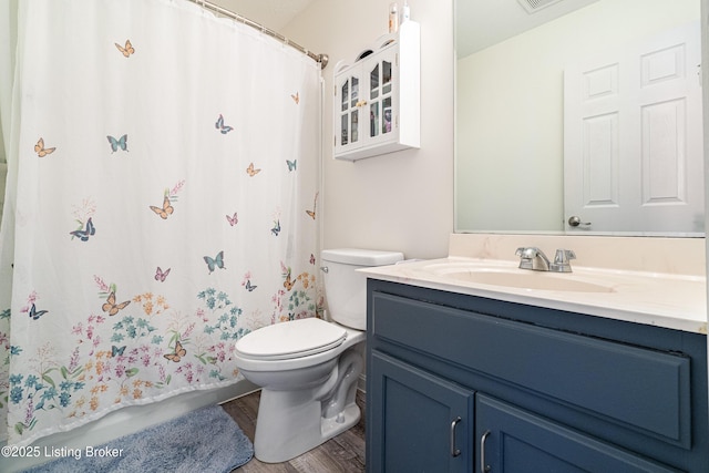 bathroom with visible vents, toilet, wood finished floors, a shower with shower curtain, and vanity