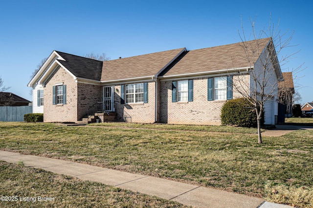 ranch-style house with brick siding, a shingled roof, a front yard, and fence