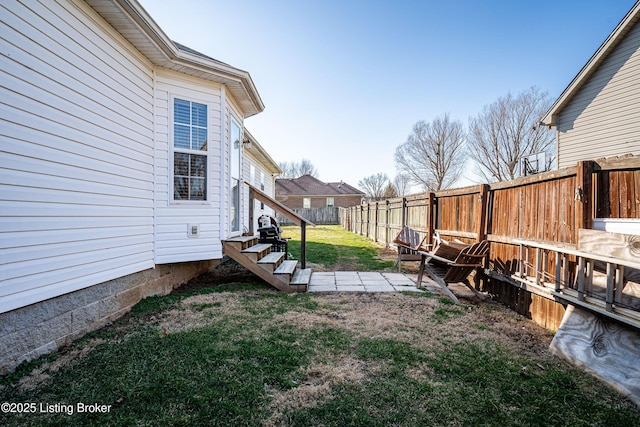 view of yard featuring entry steps and a fenced backyard