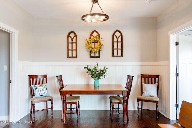 dining room with a wainscoted wall and wood finished floors