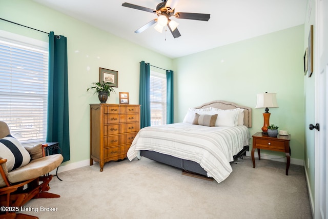 bedroom with a ceiling fan, light colored carpet, and baseboards