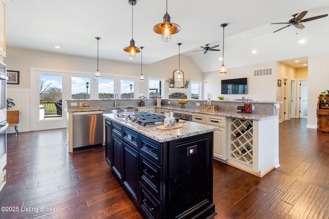 kitchen featuring visible vents, dark wood-type flooring, a spacious island, stainless steel appliances, and lofted ceiling