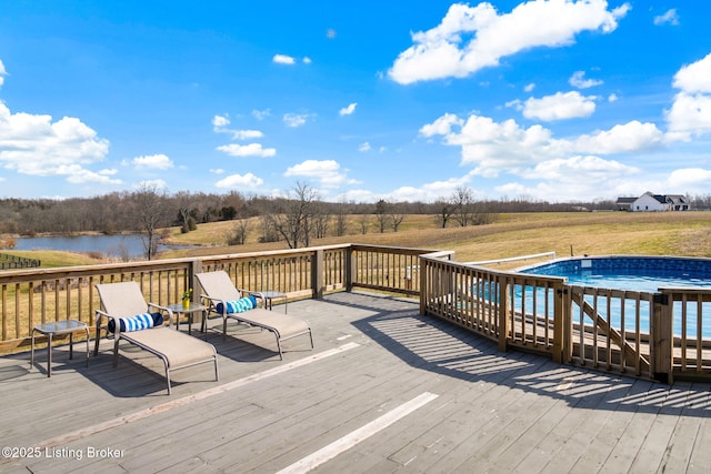 wooden deck with a lawn, an outdoor pool, and a water view