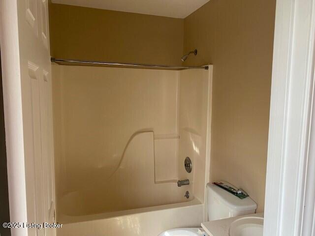 bathroom featuring shower / bathing tub combination, toilet, and vanity