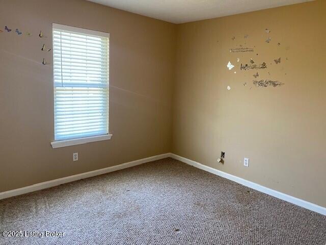 carpeted spare room with baseboards