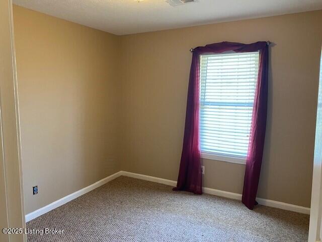 spare room with light colored carpet and baseboards