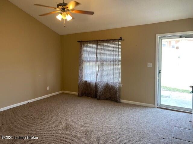 spare room with lofted ceiling, carpet flooring, a ceiling fan, and baseboards