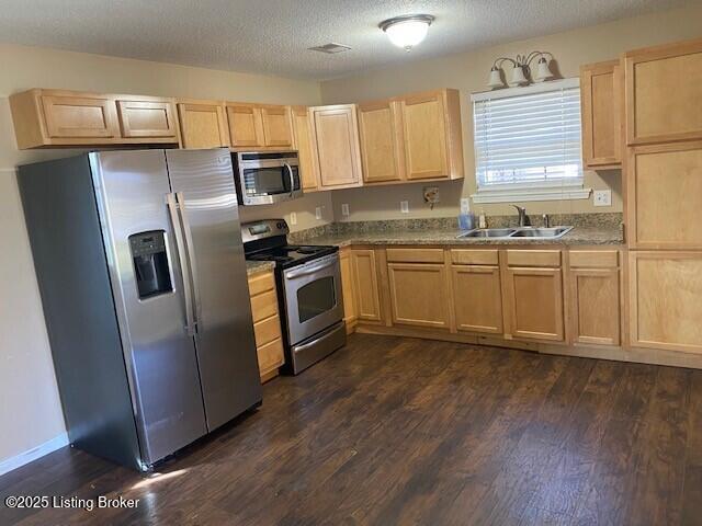 kitchen featuring a sink, dark wood-type flooring, light brown cabinetry, and stainless steel appliances