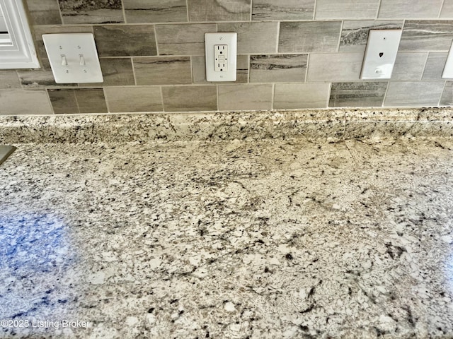 details featuring white cabinets and light stone counters