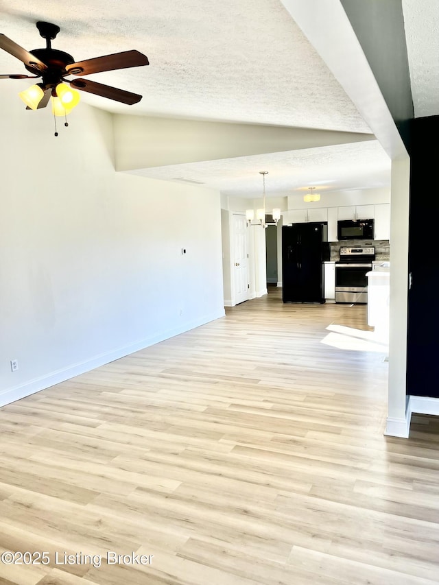 unfurnished living room featuring light wood finished floors, baseboards, lofted ceiling, ceiling fan with notable chandelier, and a textured ceiling