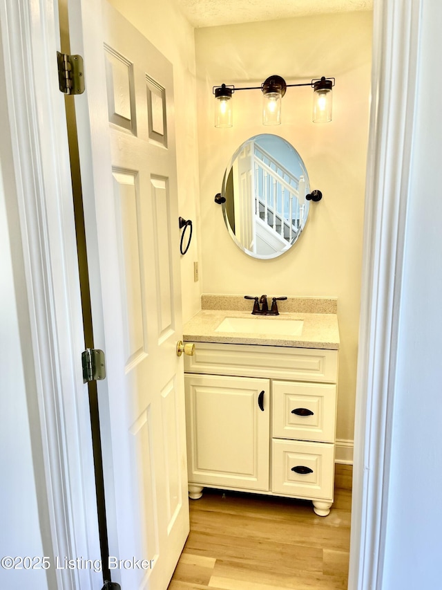 bathroom with wood finished floors and vanity