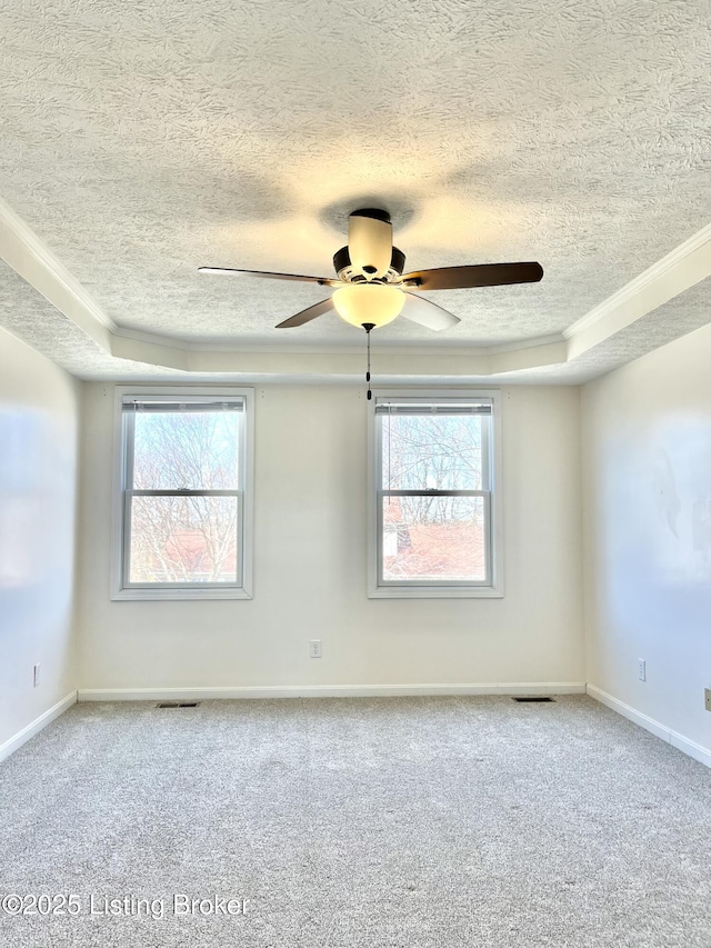 spare room featuring plenty of natural light, carpet, and visible vents