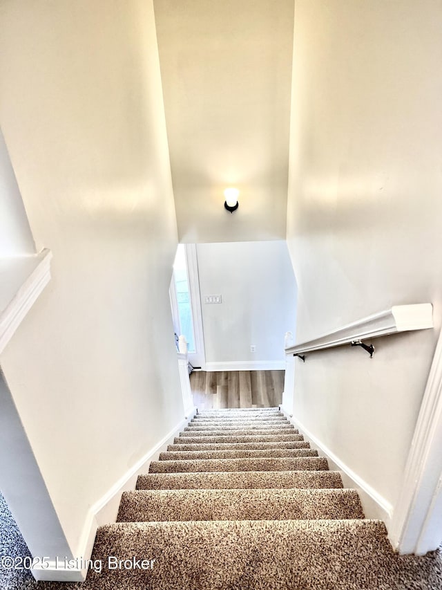 stairs featuring wood finished floors and baseboards