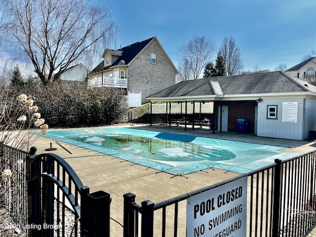 community pool with a patio and fence