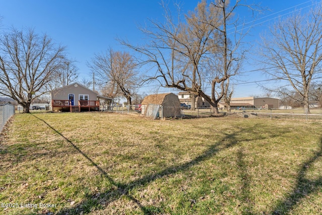 view of yard with an outdoor structure, a fenced backyard, and a wooden deck