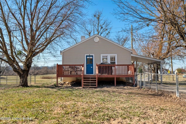 view of front of home featuring a deck, a chimney, a front yard, and fence