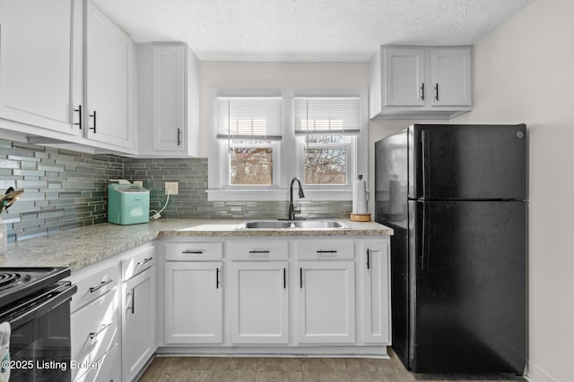 kitchen with white cabinetry, black appliances, backsplash, and a sink