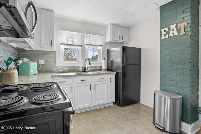 kitchen featuring a sink, decorative backsplash, black appliances, white cabinets, and a textured ceiling