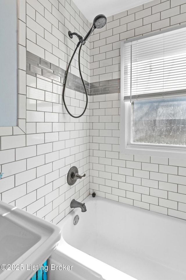 bathroom with bathing tub / shower combination and a sink