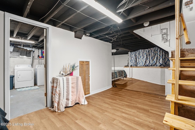 unfinished basement with wood finished floors and washer and clothes dryer