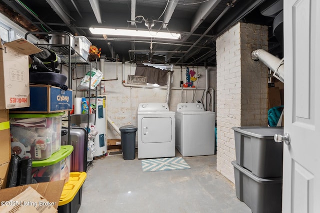 unfinished basement featuring independent washer and dryer, brick wall, and electric water heater