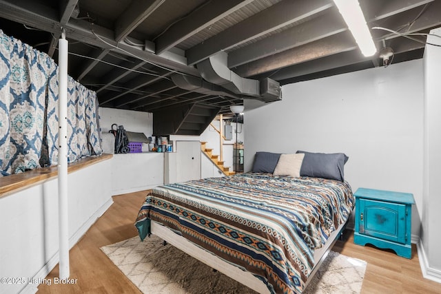 bedroom featuring wood finished floors and baseboards