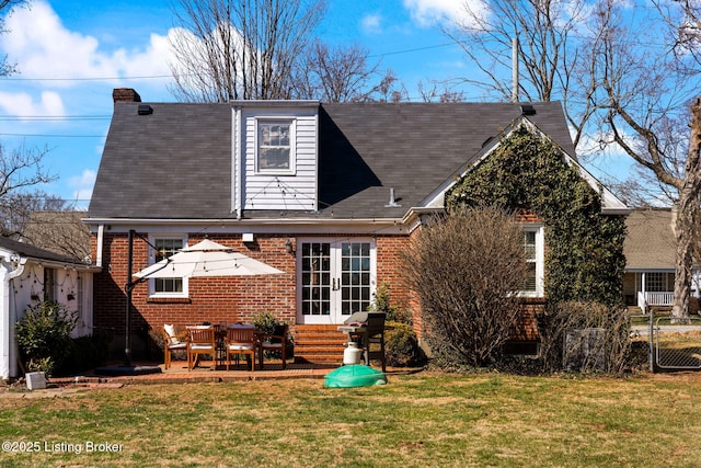 back of property featuring entry steps, french doors, a lawn, a patio area, and brick siding