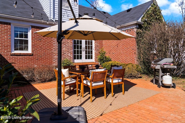 view of patio / terrace featuring french doors, outdoor dining area, and a grill