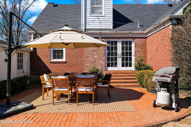 view of patio / terrace featuring area for grilling, french doors, outdoor dining space, and entry steps