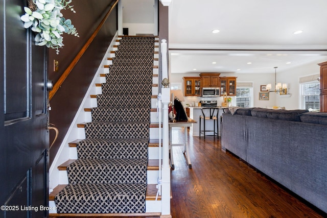 stairs featuring a chandelier, recessed lighting, and wood finished floors