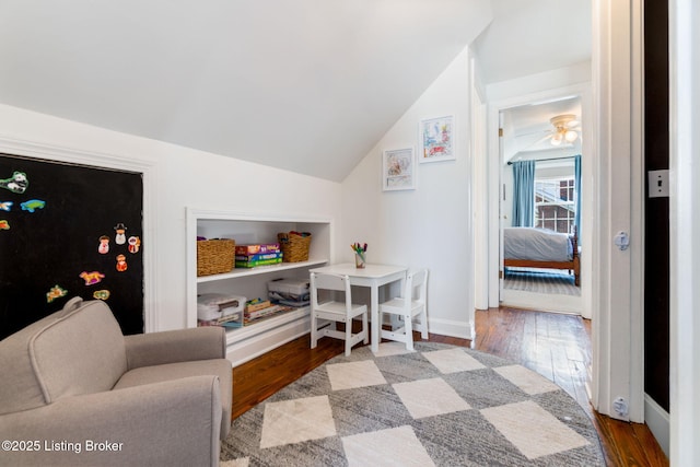 interior space featuring hardwood / wood-style flooring, baseboards, and vaulted ceiling