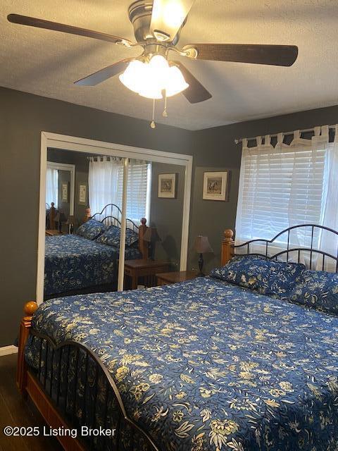 bedroom with a closet, a textured ceiling, wood finished floors, and a ceiling fan