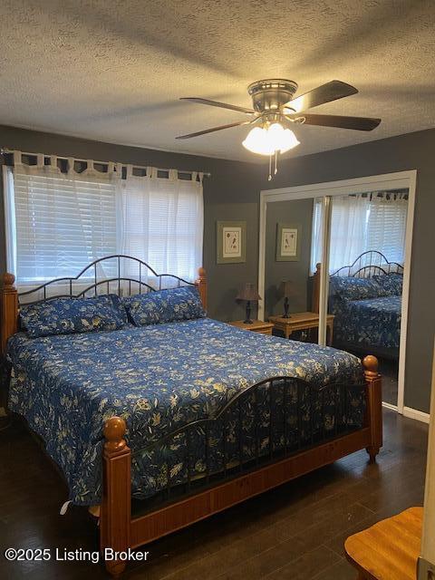 bedroom with a textured ceiling, wood finished floors, and a ceiling fan