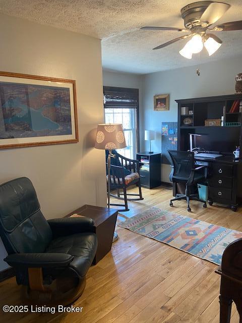 office space with a textured ceiling, ceiling fan, and hardwood / wood-style flooring