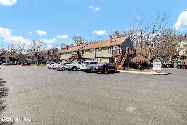 uncovered parking lot featuring a residential view and stairs